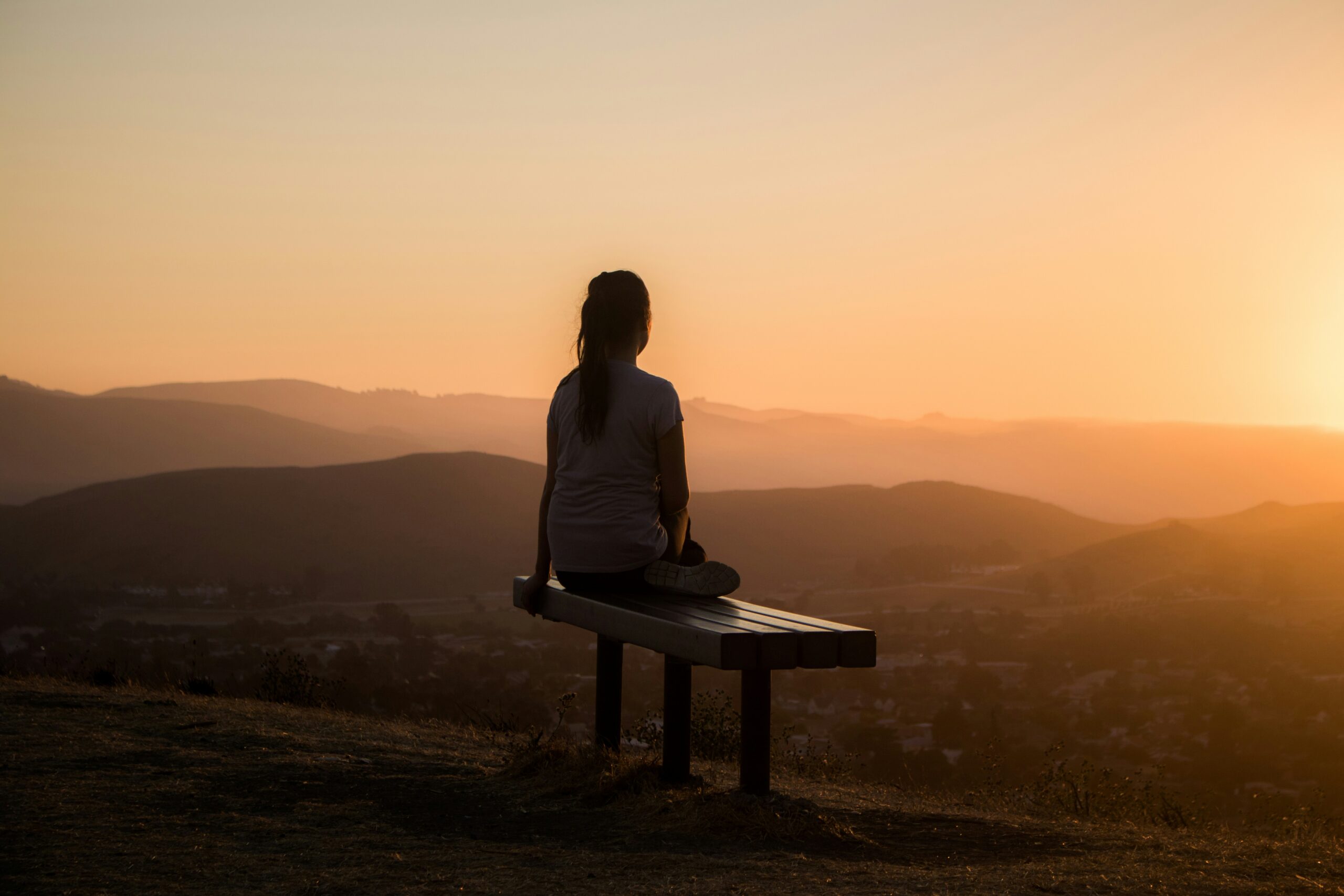 person on mountainside in sunset